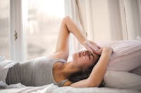 Woman in Gray Tank Top Lying on Bed